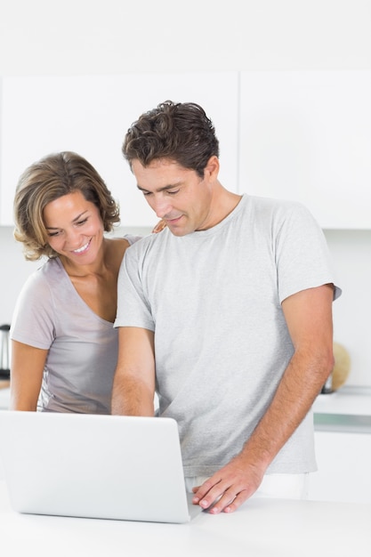 Casal sorridente usando laptop juntos