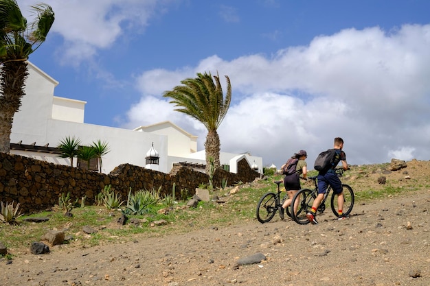 Casal subindo a estrada com bicicletas.