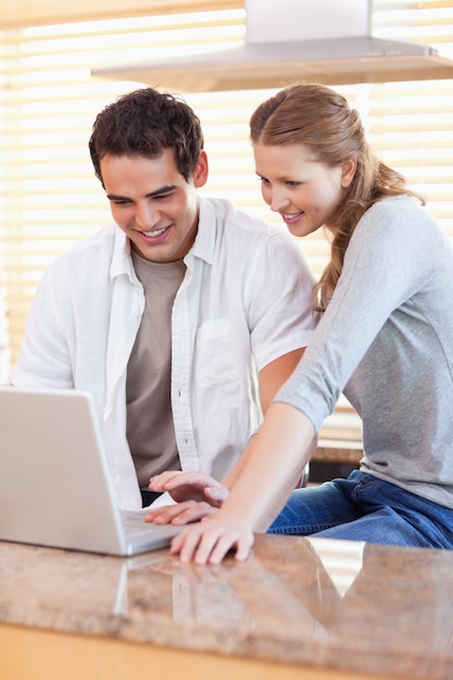 Casal surfando na web na cozinha