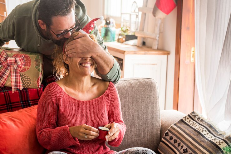 Foto casal surpresa presente de natal com homem fazendo uma surpresa para a esposa mulher em casa nas férias