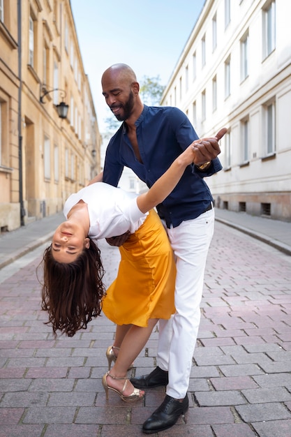 Foto casal tendo uma apresentação de dança latina na cidade