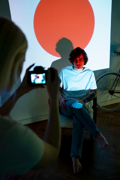 Casal tirando fotos à luz do projetor de filmes