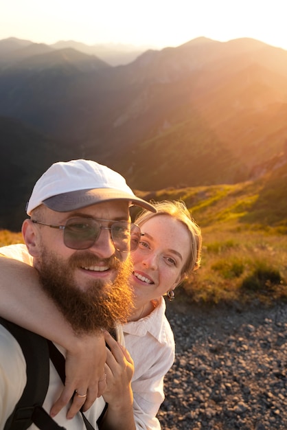 Casal tirando selfie na vista lateral da montanha