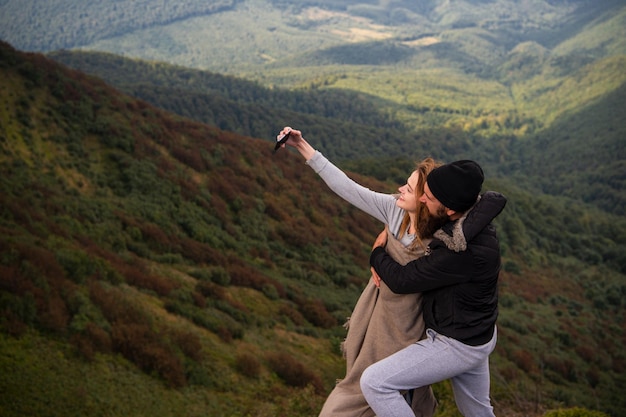 Casal tirando selfie perto da floresta, natureza e conceito de estilo de vida, amantes românticos em co