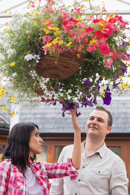 Casal tocando a cesta de flores pendurada