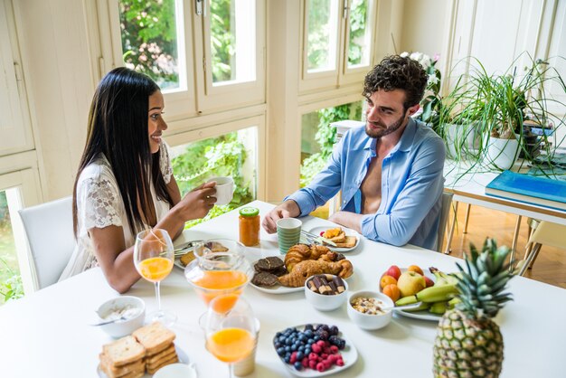 Casal tomando café da manhã em casa