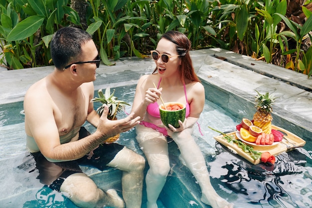 Casal tomando café da manhã na piscina