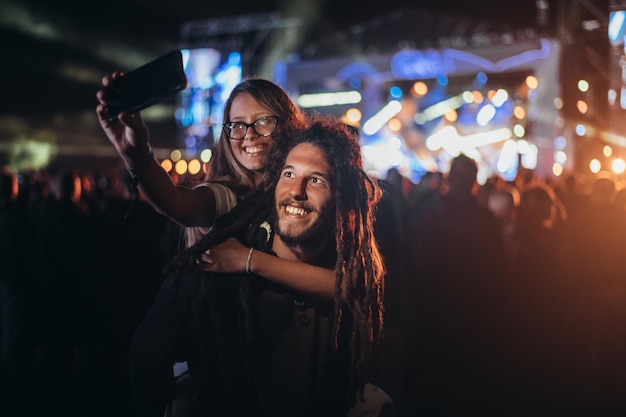 Casal tomando selfie com um smartphone em um festival de música