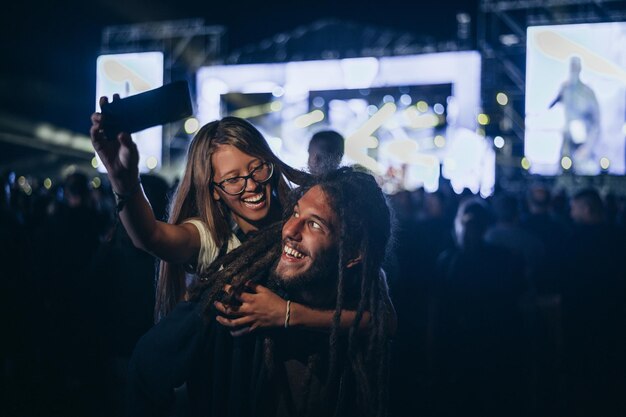 Casal tomando selfie com um smartphone em um festival de música