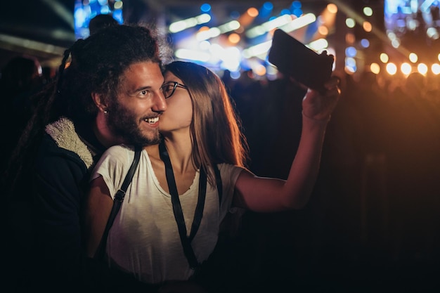 Casal tomando selfie com um smartphone em um festival de música