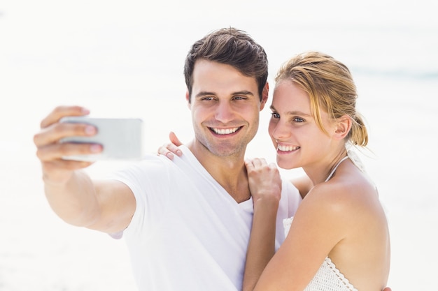 Casal tomando uma selfie na praia