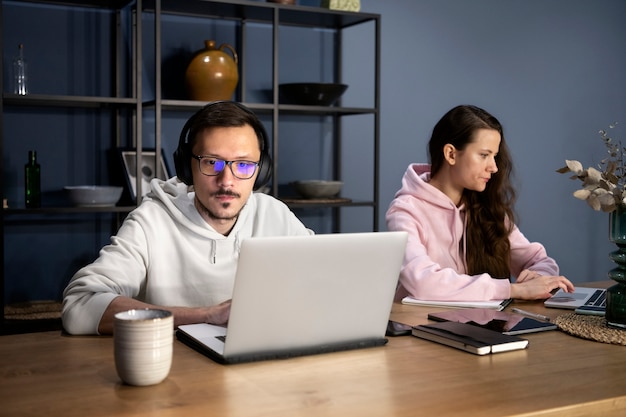 Casal trabalhando em casa em dispositivos