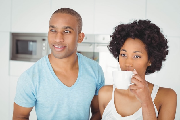 Casal tranquilo em pé na cozinha em casa