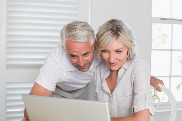 Casal usando laptop em casa