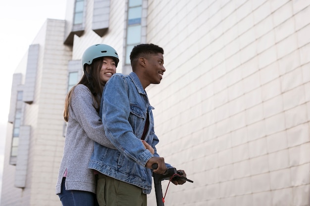 Foto casal usando scooter elétrico para transporte