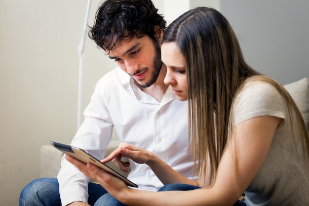 Casal usando um tablet em seu apartamento