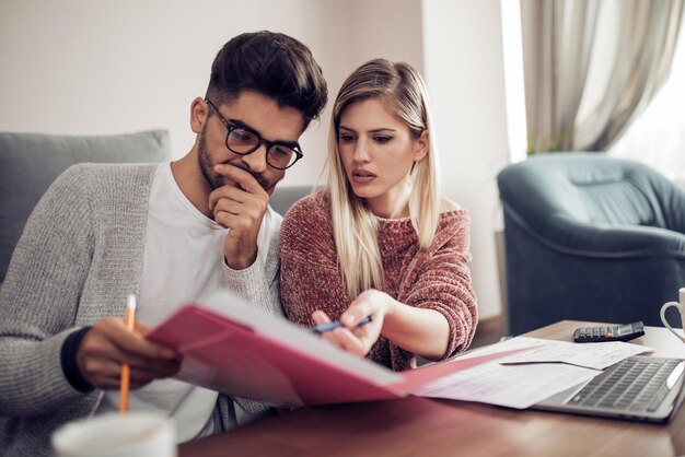 Casal verificando suas contas em casa