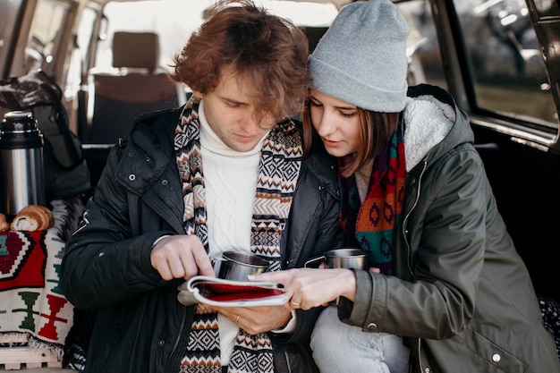 Foto casal verificando um mapa durante uma viagem