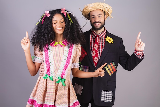 Foto casal vestindo roupas típicas da festa junina arraial festa de são joão dançando e comemorando