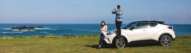 Casal viajando de carro fotografando a paisagem