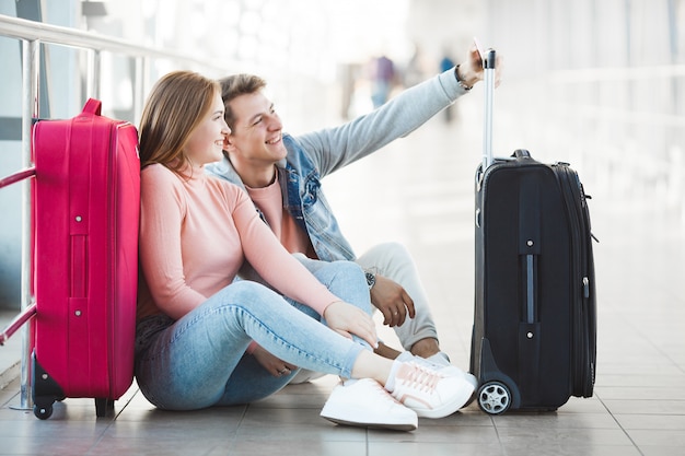 Casal viajando. Viagem de amantes. Jovem e mulher no aeroporto. Passeio em família.