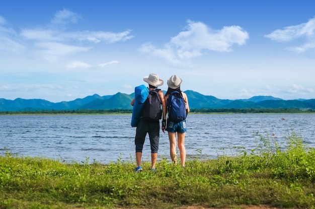 casal viajante em pé perto do lago na montanha