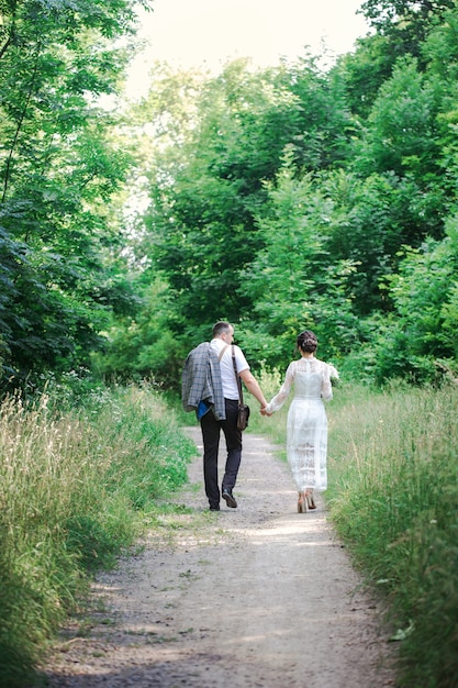 Casamento de um jovem casal lindo em estilo vintage. Recém-casados em um passeio no parque