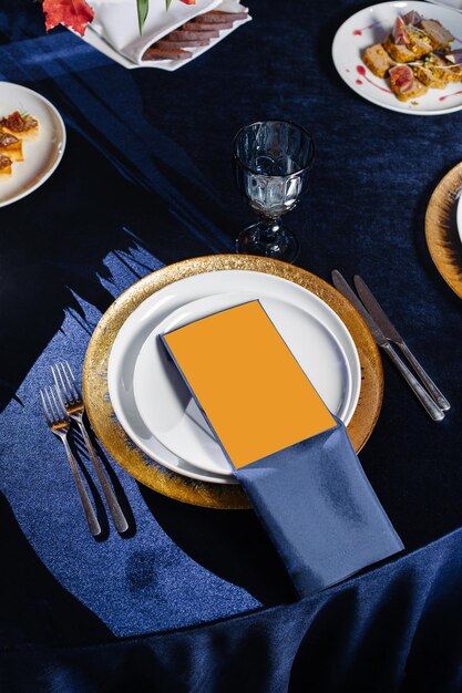 Casamento festivo, configuração de mesa de aniversário. menu vazio do restaurante simulado. configuração de mesa festiva com fita de seda azul e almofadas de ouro.