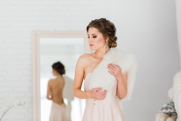 Casamento. Noiva em lindo vestido dentro de casa no interior do estúdio branco como em casa.