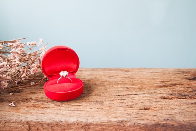 Foto casamento ou anel de casamento, anel de diamante na caixa vermelha na mesa de madeira, estilo vintage