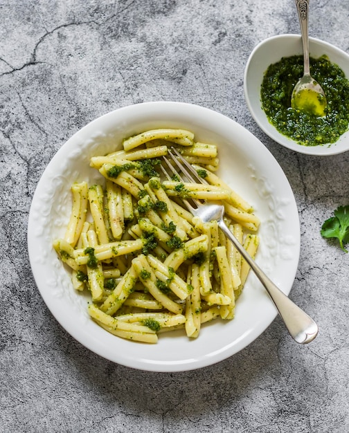 Casarecce-Nudeln mit Koriander-Pesto-Sauce auf grauem Hintergrund, Draufsicht Köstliches vegetarisches Mittagessen