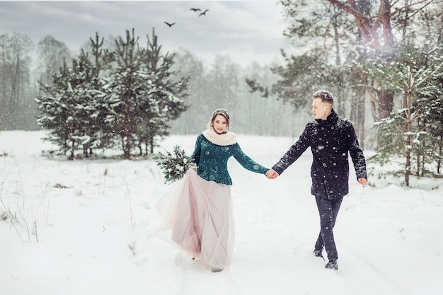 Casarse pareja caucásica en temporada de invierno cerca retrato al aire libre. Amorosa linda tierna pareja de enamorados caminando juntos en un bosque vistoso