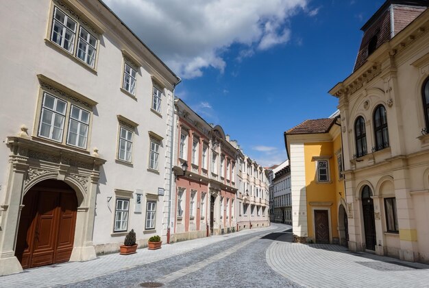 Casas antiguas coloridas con una calle curva y un cielo azul mientras se camina en Hungría