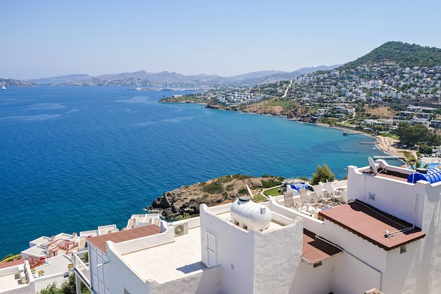 Casas brancas de férias no resort com vista para o mar e palmeiras e vista para a cidade.