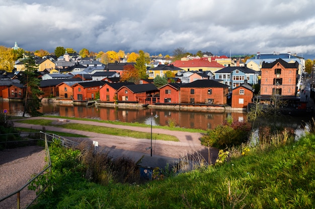 Casas clásicas de madera rojas viejas y su reflejo en el río. Porvoo, Finlandia