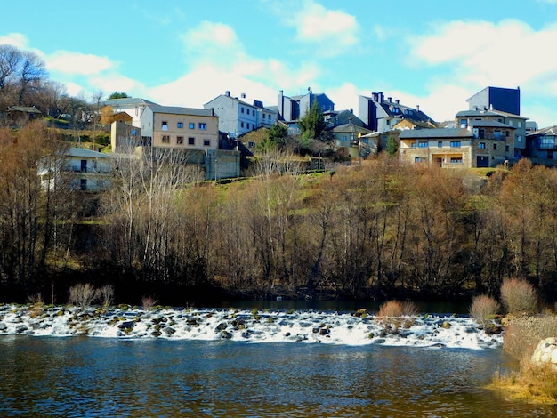Casas en una colina con vistas a un río y un edificio con techo azul.