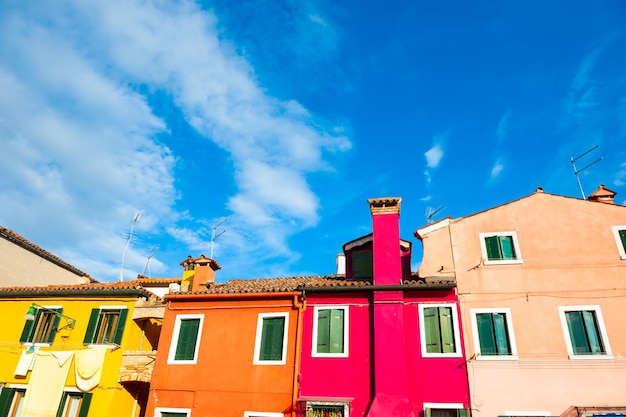 Casas coloridas contra o céu azul. Arquitetura multicolor na ilha de Burano, Veneza, Itália