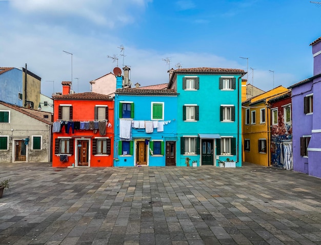 Casas coloridas em uma pequena praça tradicional na ilha de Burano, Veneza, Itália