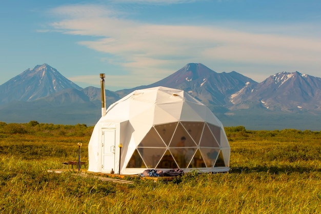 Casas de barracas com paisagem rural de vulcão e casa glamorosa em foco seletivo da península de Kamchatka
