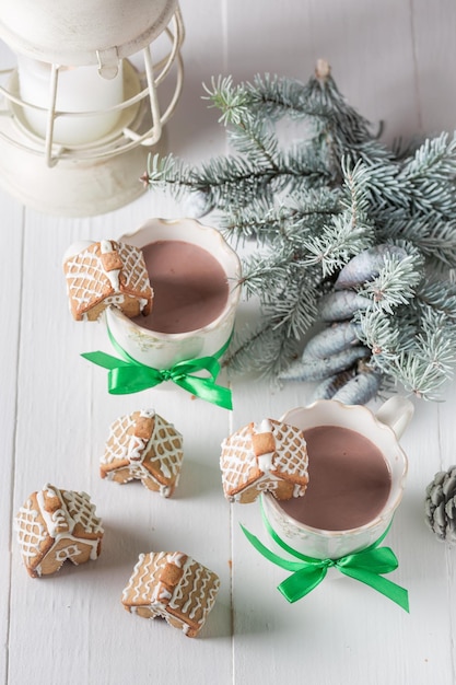 Casas de gengibre bonitos com chocolate quente na noite de inverno de Natal