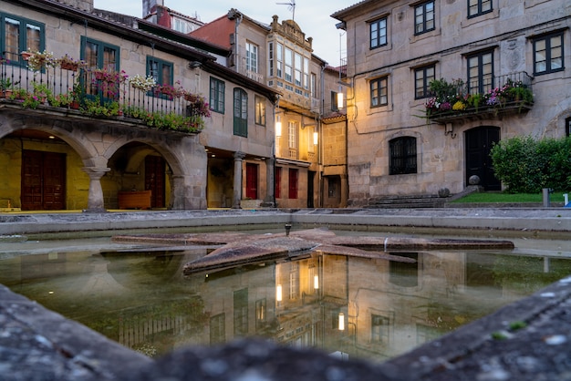 Casas de granito refletidas na água na praça Herraria, em Pontevedra, Galiza, Espanha