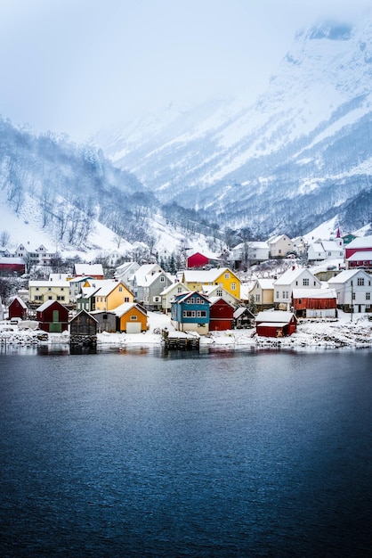 Casas de madeira nas margens do fiorde norueguês bela paisagem montanhosa no inverno