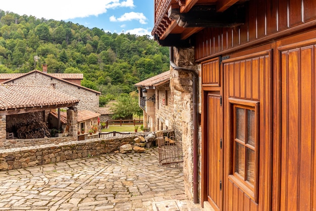 Casas de pedra pitorescas com flores e ruas estreitas em uma das aldeias mais bonitas da Espanha Barcena Mayor Cantabria