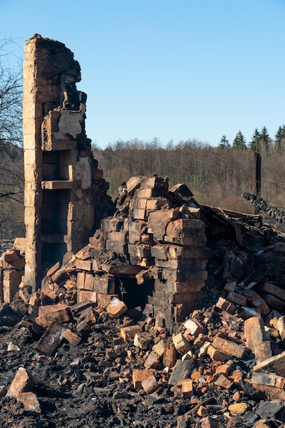 Casas destruídas como resultado de um incêndio na Rússia Tijolos e partes de paredes vários utensílios domésticos janelas quebradas cobertas de cinzas na superfície da terra Desastre natural