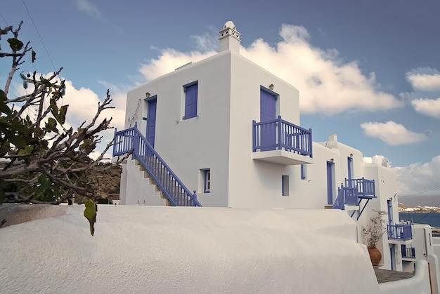 Casas em Mykonos Grécia Edifícios caiados de branco com janelas e portas pintadas de azul no céu ensolarado Arquitetura e design típicos Férias de verão na ilha mediterrânea Conceito de viagem e viagem