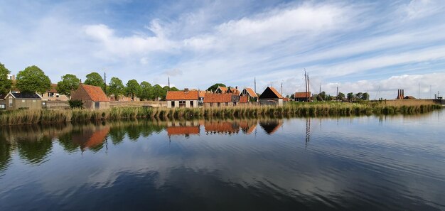 Casas holandesas históricas ao lado do lago numa manhã ensolarada de primavera