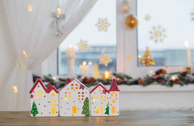 Casas de juguete de Navidad en el fondo de la ventana decorada