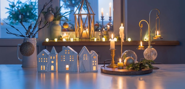 Casas de juguete de Navidad con velas encendidas en la mesa