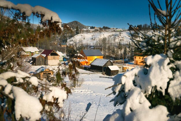Casas de madera en una aldea en la nieve noche de invierno bajo un cielo azul oscuro con estrellas