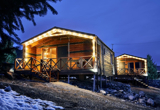 Casas de madera con lámparas que brillan intensamente en la noche